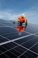 Technician installing solar panels on factory roof for green energy. A skilled technician in safety gear is working on a solar panel installation on rooftop.