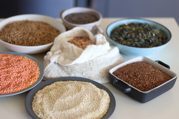 Bowls and bags full of various healthy grains and legumes. Selective focus.