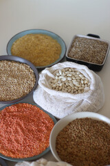 Bowls and bags full of various healthy grains and legumes. Selective focus.