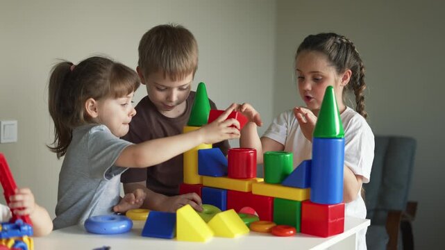 Children build colorful block castle together at table with girl and boy play with toy block building in preschool setting promoting learning creativity teamwork fine motor skill and imaginative play