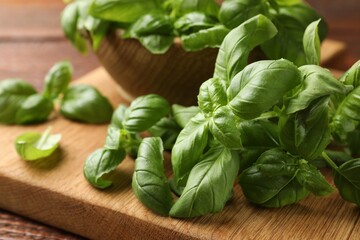 Fresh basil leaves on wooden table, closeup