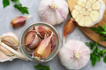 Garlic and parsley on light table, flat lay