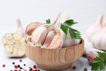 Garlic, peppercorns and parsley on white table, closeup