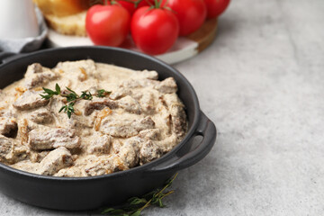 Tasty beef Stroganoff with thyme served on grey table, closeup. Space for text
