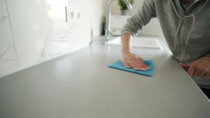 Woman Wiping Counter Surface During Cleaning In Kitchen