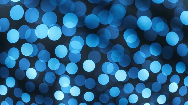 Close-up of shimmering blue circular bokeh lights shifting on a dark background creating a visually dynamic scene with a gradual increase in luminosity and focus throughout the footage