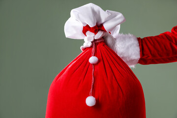 Santa Claus holding sack on grey background, closeup with space for text. Merry Christmas and Happy...