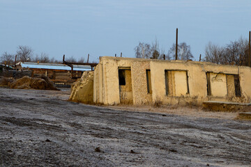 Abandoned, Earth-Toned Concrete Structure with Boarded-Up Windows and Frosted Ground