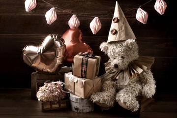 Vintage style teddy bear in paper ruff collar and a cap at a birthday party in sepia color