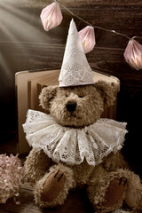 Portrait of vintage style teddy bear in lace ruff collar and a cap in sepia color