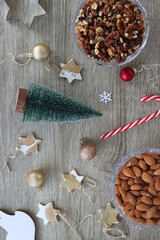 Various Christmas decorations, cookies, chocolate and nuts on wooden background. Flat lay.
