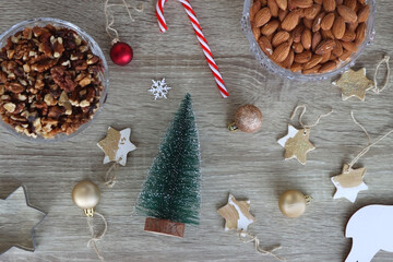 Various Christmas decorations, cookies, chocolate and nuts on wooden background. Flat lay.