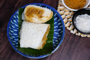 A closeup shot of a traditional Goan Alle Belle coconut pancakes. The crepes are rolled neatly and filled with a rich, dark brown mixture of grated coconut and palm jaggery. popular tea time snack.