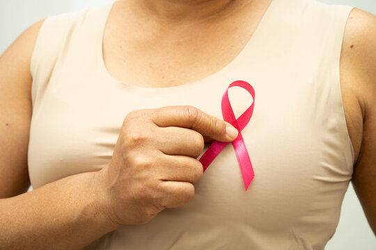 Asian woman with pink ribbon for October world breast cancer day.