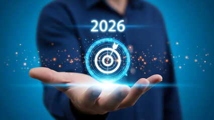 Fototapeta premium Hand holding a glowing target icon with the year 2026, symbolizing future business goals, strategic planning, vision, and success achievement for growth.