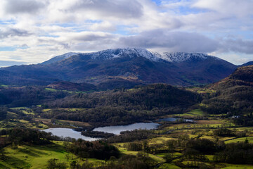 Obraz premium Loughrigg fell overlooking snow-capped peaks and lakes in the Lake District.