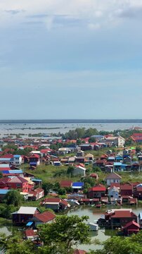 Viewpoint of a flooded fishing village near the Krahom Temple, Cambodia. From the mountain Krahom (Pnom Krom) overlooking the lake Tonlesap. Houses are built on high stilts. Rainy season. 4К