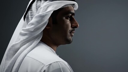 Man in traditional white attire, head covering, posed in profile against a muted gray backdrop tone!!