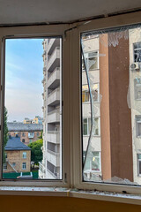 KYIV, UKRAINE - JUNE 6, 2025: Damage to the balcony of a residential building after a drone strike, showing broken windows and debris on the wall.