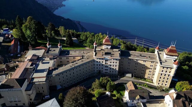 Aerial drone footage of SHMS Swiss Hotel Management School campus in Montreux, Switzerland, showcasing modern architecture, scenic Lake Geneva, and surrounding mountains