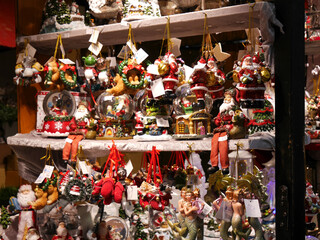 bunte Anhänger, Figuren und baumschmuck an einem Verkaufsstand auf dem Weihnachtsmarkt