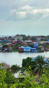 Viewpoint of a flooded fishing village near the Krahom Temple, Cambodia. From the mountain Krahom (Pnom Krom) overlooking the lake Tonlesap. Houses are built on high stilts. Rainy season. 4К