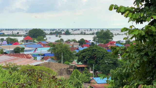 Viewpoint of a flooded fishing village near the Krahom Temple, Cambodia. From the mountain Krahom (Pnom Krom) overlooking the lake Tonlesap. Houses are built on high stilts. Rainy season. 4К