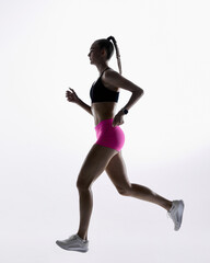 Female athlete jogging in clean minimal studio light. Concept of cardio demonstration, exercise...