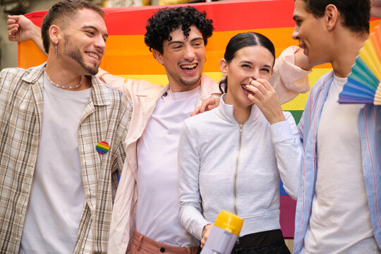 Group of diverse friends celebrating equality, smiling and laughing at a pride event