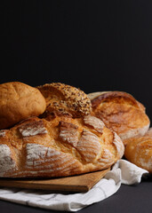Naklejka premium Vertical photo format. A delightful variety of Fresh Breads, beautifully displayed against a bright background