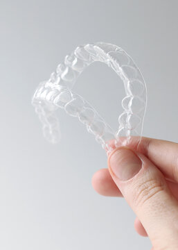 Aligners for straightening teeth on a light background. Vertical photo format