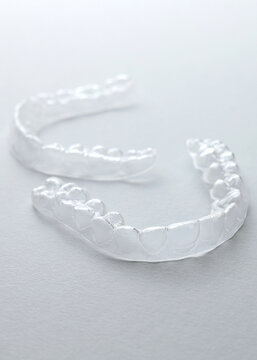 Aligners for straightening teeth on a light background. Vertical photo format