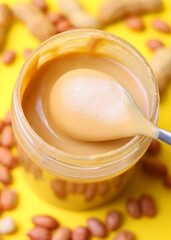 peanut butter and raw peanuts on a light background. Vertical photo format