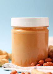peanut butter and raw peanuts on a light background. Vertical photo format