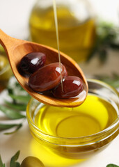Vertical photo format. A premium olive oil with olives and fresh leaves, top view 