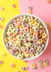 Vertical photo format.Multicolored corn rings for breakfast on a colored background