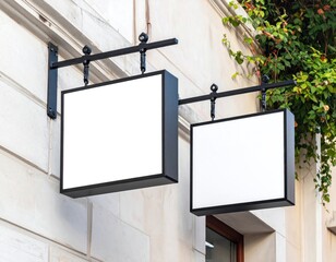 Two blank signs hanging from decorative mounts on a building
