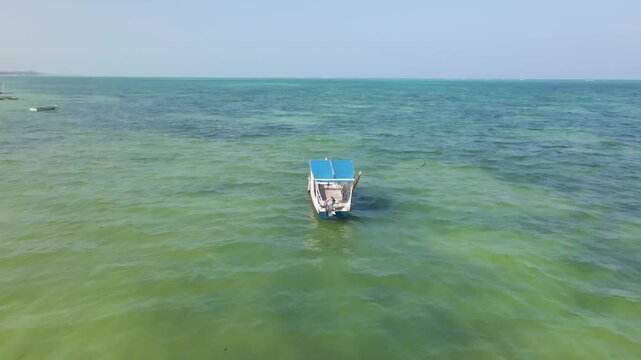 Traditional dhow boat anchored in turquoise zanzibar water