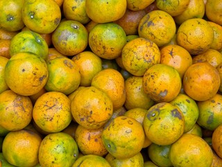 A pile of fresh mandarin oranges at a market. Background style.