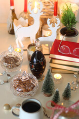 Cookie jar, tea, wine, nuts, books, lit candles and Christmas decorations on the table. Cozy Christmas hygge at home. Selective focus.