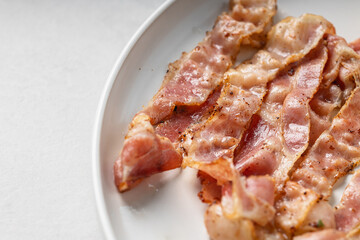 Close-up of crispy bacon slices on white plate