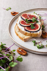 Slices of white bread with young cream cheese, freshly sliced figs and radish sprouts.