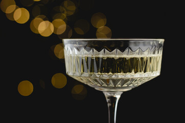 Close-up of crystal champagne glass with golden reflections