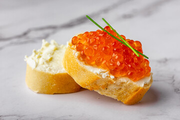 Red caviar sandwich on marble with soft cheese