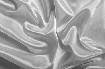 Shiny silver satin fabric is draped and wrinkled, creating a luxurious and flowing background texture.