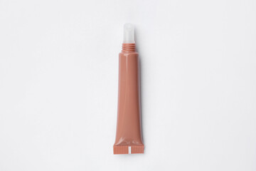 Beautiful nude lip gloss on white background, top view