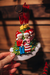 A woman's hand holding a ceramic Christmas toy souvenir in the form of magical elves, cute and cozy Christmas decor
