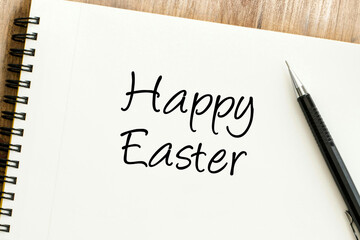 Joyful Happy Easter message handwritten on a clean spiral notebook, next to a pen, perfect for spring holiday wishes
