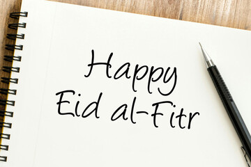 Warm wishes for Eid al Fitr, a festive occasion marking the end of Ramadan, written elegantly on a desk notepad