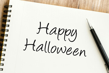 Festive handwritten Happy Halloween message on a spiral notebook, ready for holiday greetings and seasonal celebrations